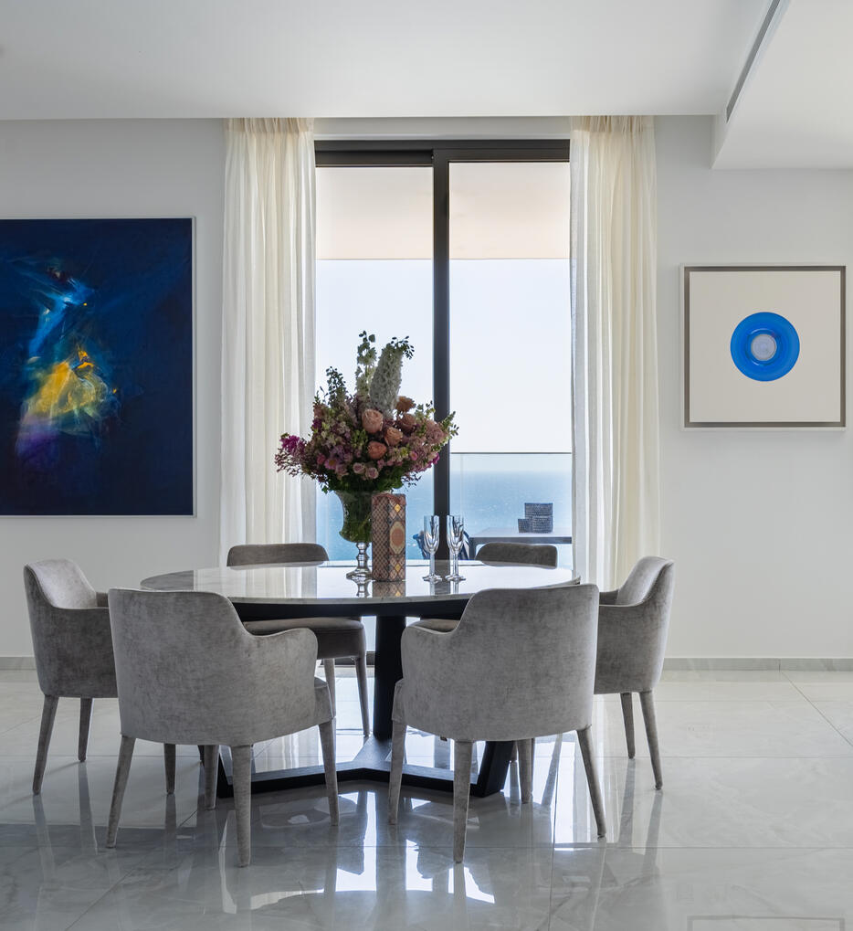 Elegant Dining Area with Sea View in Limassol Interior photography of an elegant dining area in a high-rise apartment in Limassol, Cyprus, with sea views, floral details and contemporary artwork.